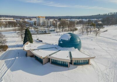 Winterliche Außenaufnahme des Planetariums Wolfsburg mit verschneiter Kuppel und umliegendem Park im Schnee.