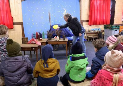 Kinder erleben eine kostenfreie Märchenstunde mit Frau Sterz im festlich dekorierten Neulandhaus des Weihnachtsmanns auf dem Wolfsburger Weihnachtsmarkt – ein Angebot für Kitas im Advent 2025.