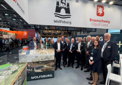 viele Menschen in Anzügen stehen an dem Wolfsburger Messestand auf der Expo Real
